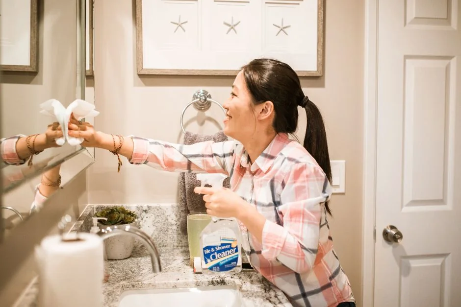 A uniformed cleaner holding a basin with cleaning supplies indoors. Ideal for cleaning and sanitation themes.